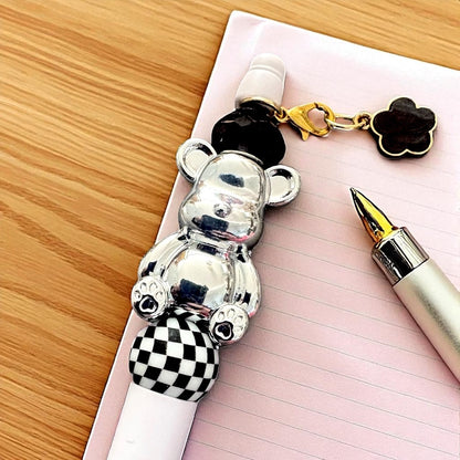 Handcrafted black ballpoint pens with adorable gummy bear and teddy bear charms.