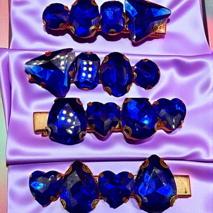 Set of blue gemstone hair clips on a purple satin background
