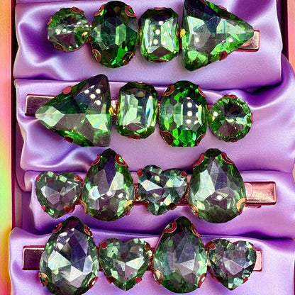 Green gemstone hair clips on a purple background