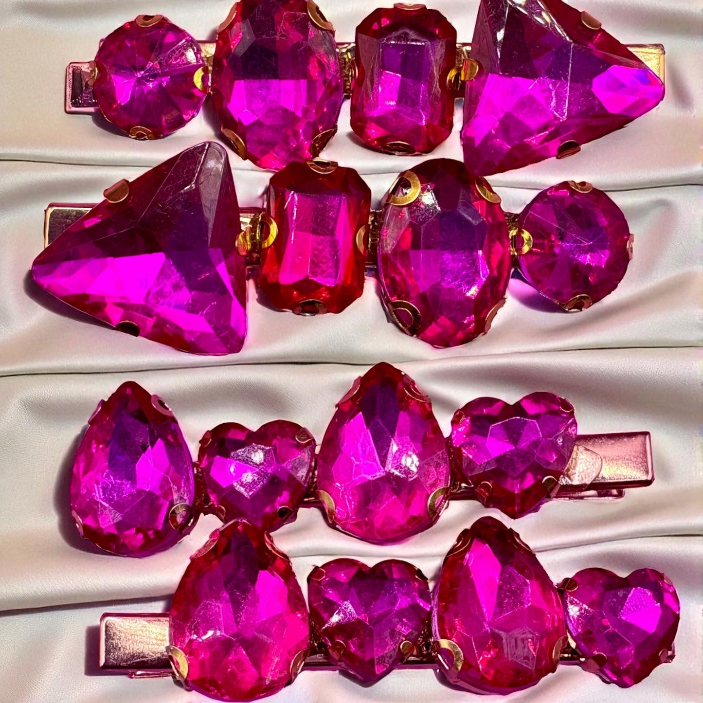 Set of pink gemstone hair clips on a white satin background