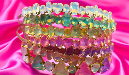 Stack of colorful beaded headbands on a pink satin background