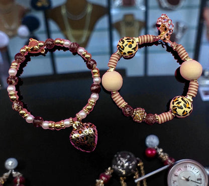 Pair of hoop earrings with beaded designs on a dark surface
