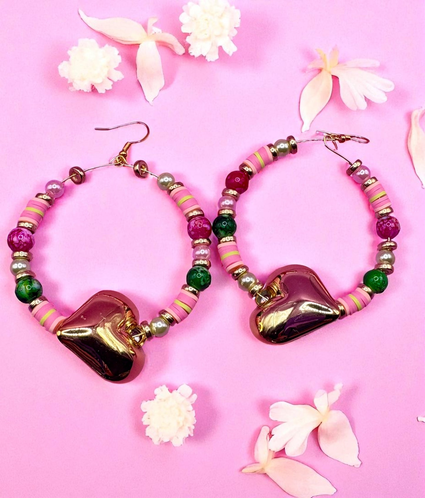 Heart-shaped beaded earrings on a pink background with flowers