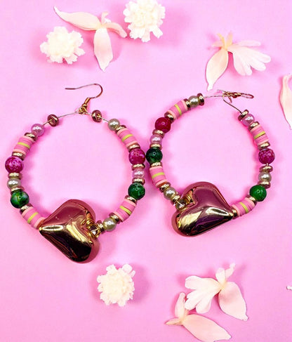 Heart-shaped beaded earrings on a pink background with flowers