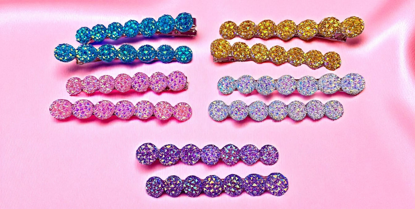 Set of colorful rhinestone hair clips on a pink background