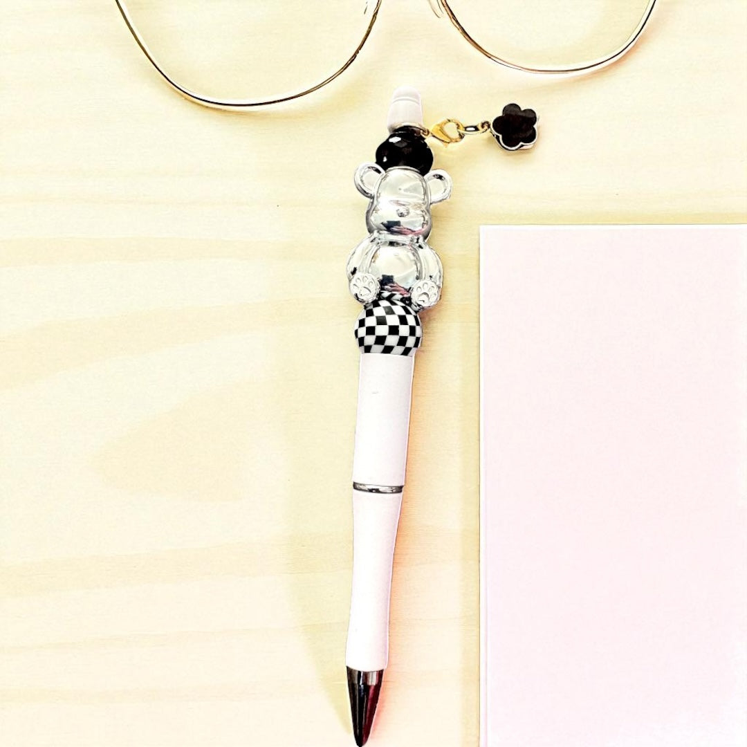 Pen with a bear-shaped clip on a light yellow background