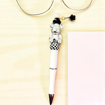 Pen with a bear-shaped clip on a light yellow background