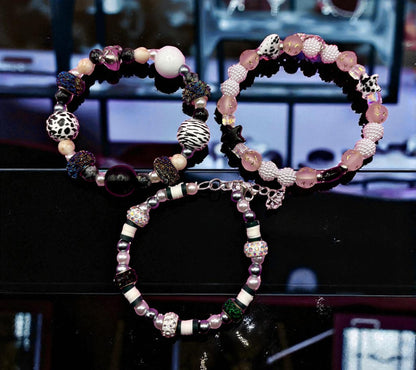 Two beaded bracelets on a dark surface with a blurred background
