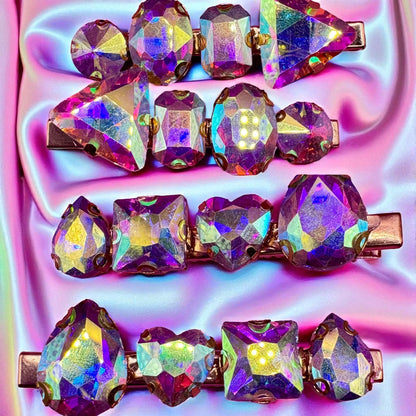 Multicolored gemstone hair clips on a vibrant pink and purple background
