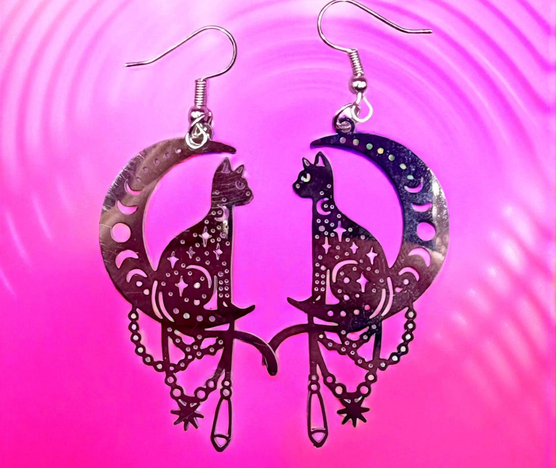 Cat and moon earrings on a pink and purple gradient background