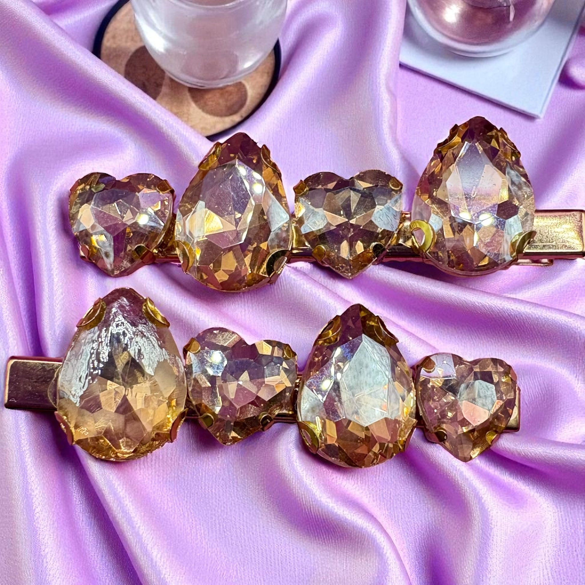 Heart-shaped crystal hair clips on a purple satin background