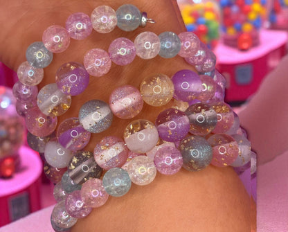 Multicolored beaded bracelets on a wrist with a blurred colorful background