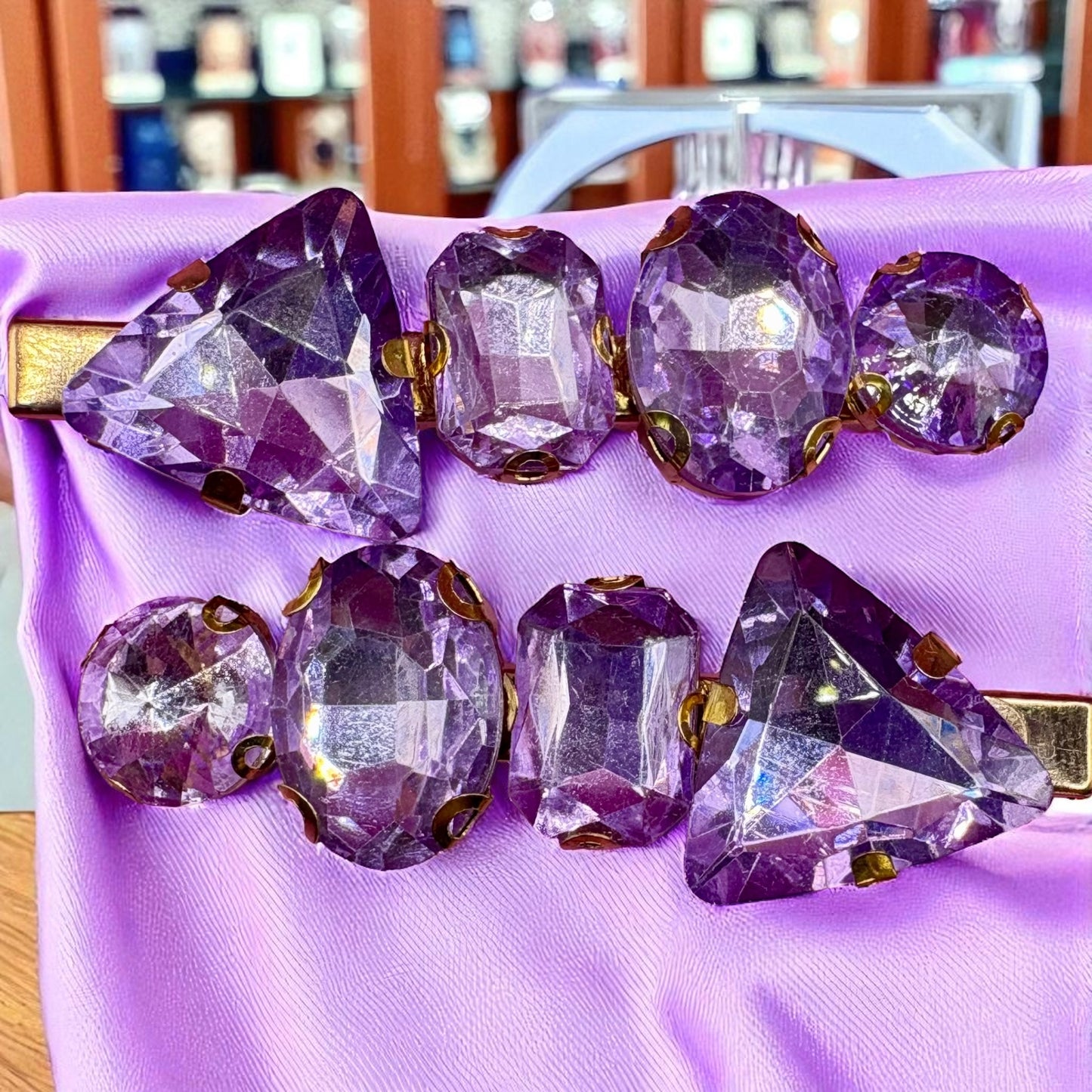 Purple gemstone hair clips on a purple fabric background