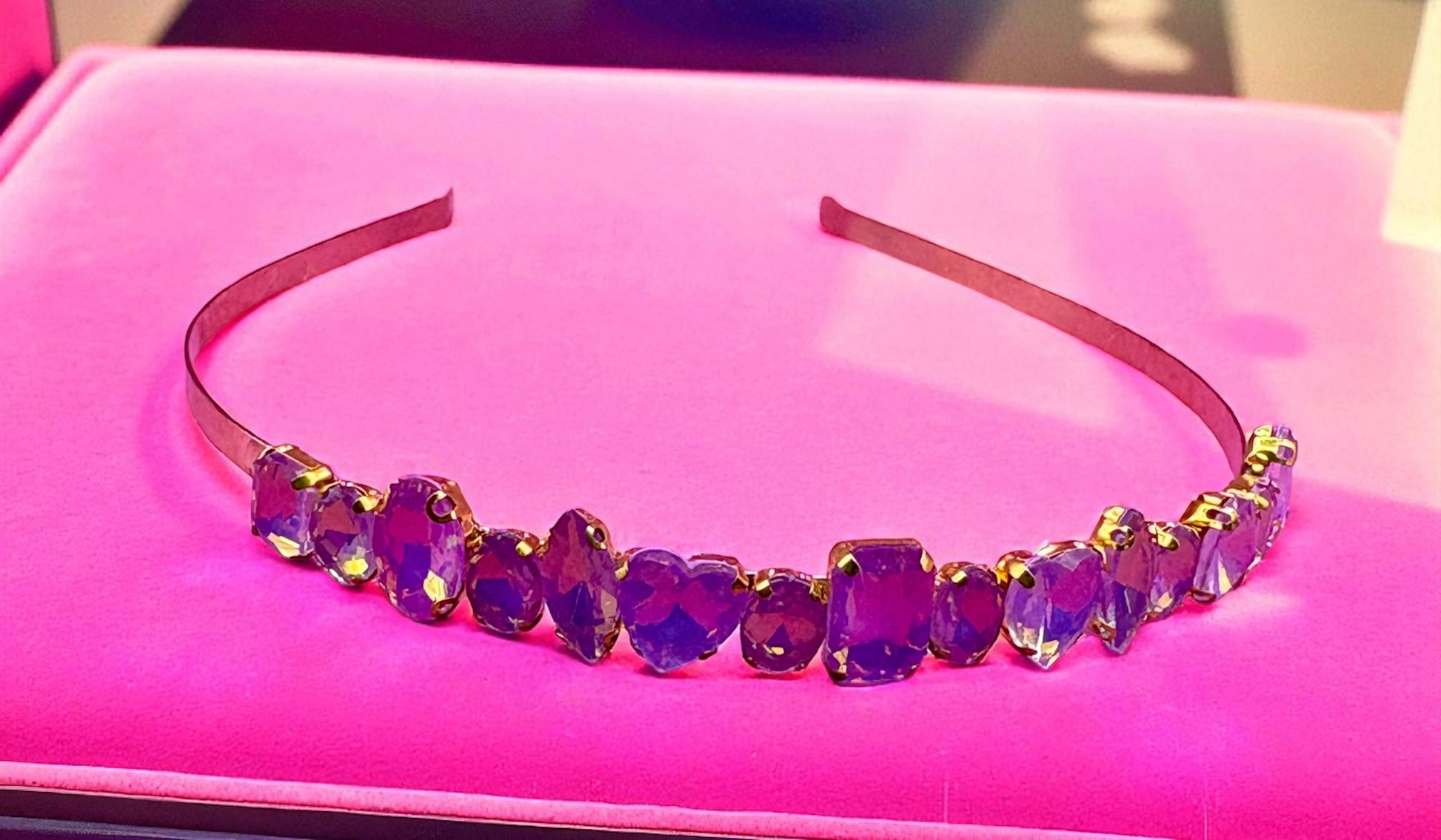 Purple beaded headband on a pink surface