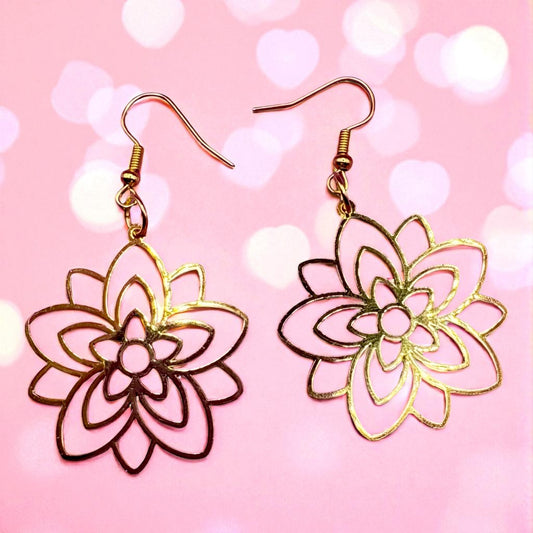 Pair of floral earrings on a pink background with heart shapes