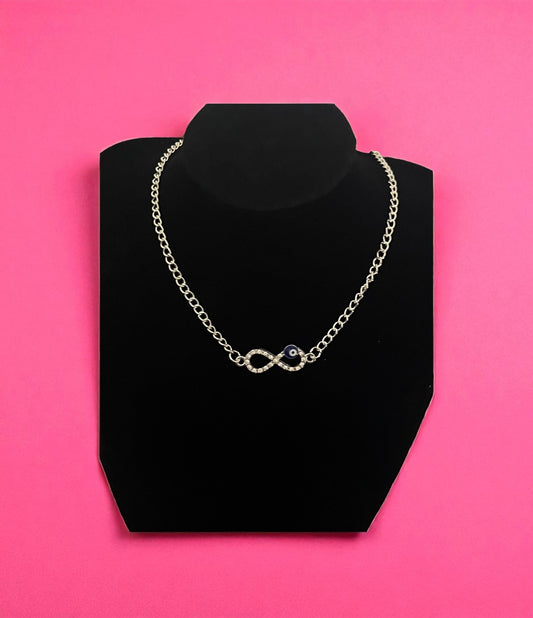 Necklace on a black stand against a pink background