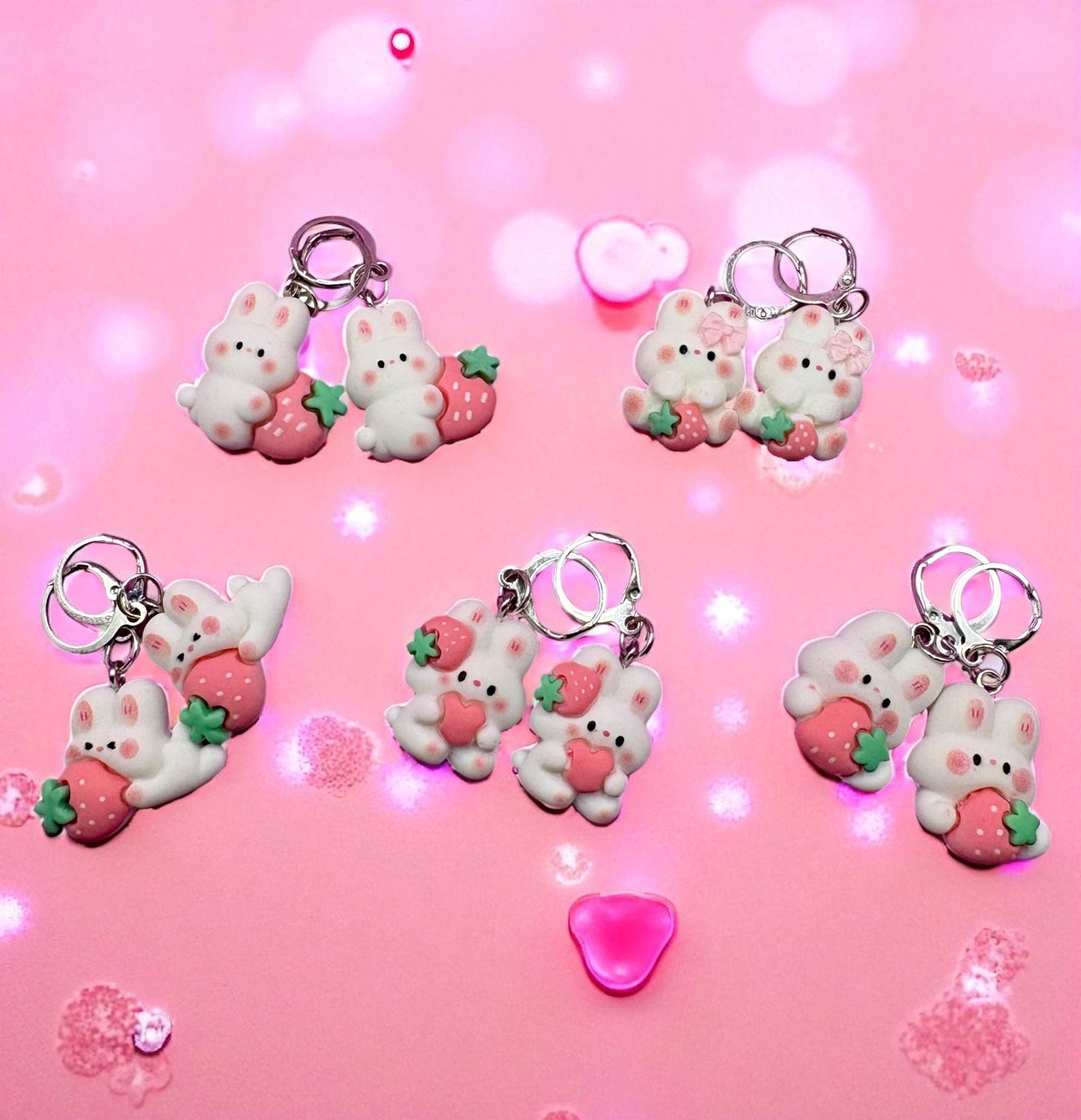 Set of cute keychains with bear and strawberry designs on a pink background