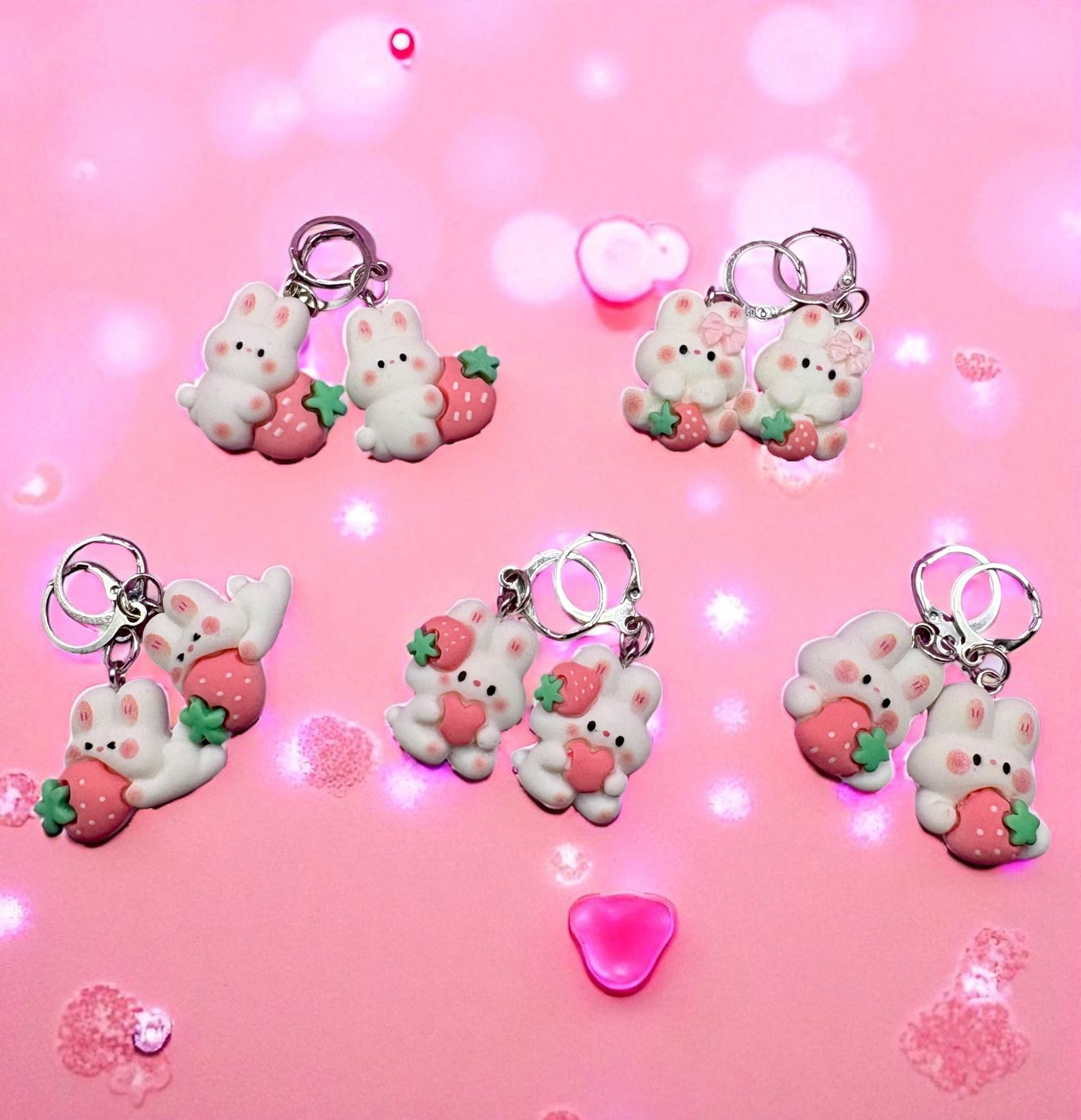 Set of cute keychains with bear and strawberry designs on a pink background