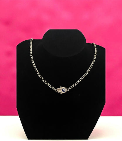 Necklace with an eye-shaped pendant on a black stand against a pink background