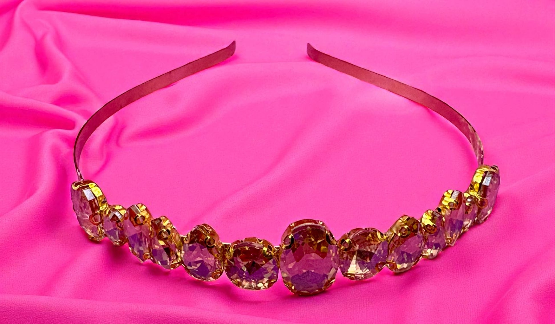 Decorative headband with colorful beads on a pink fabric background