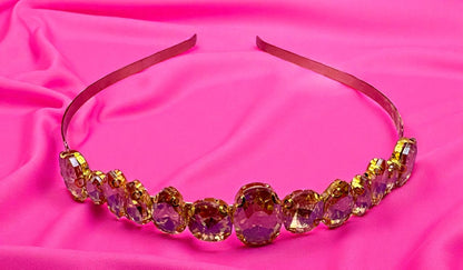 Decorative headband with colorful beads on a pink fabric background