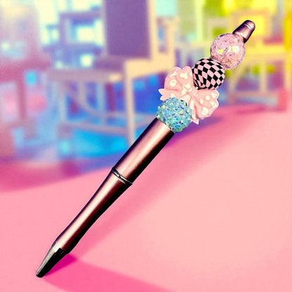 Decorative pen with colorful beads on a pink surface