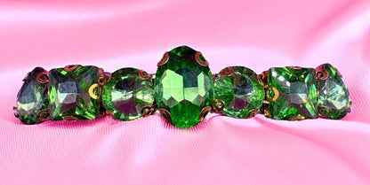 Green crystal hair clips  on a pink fabric background