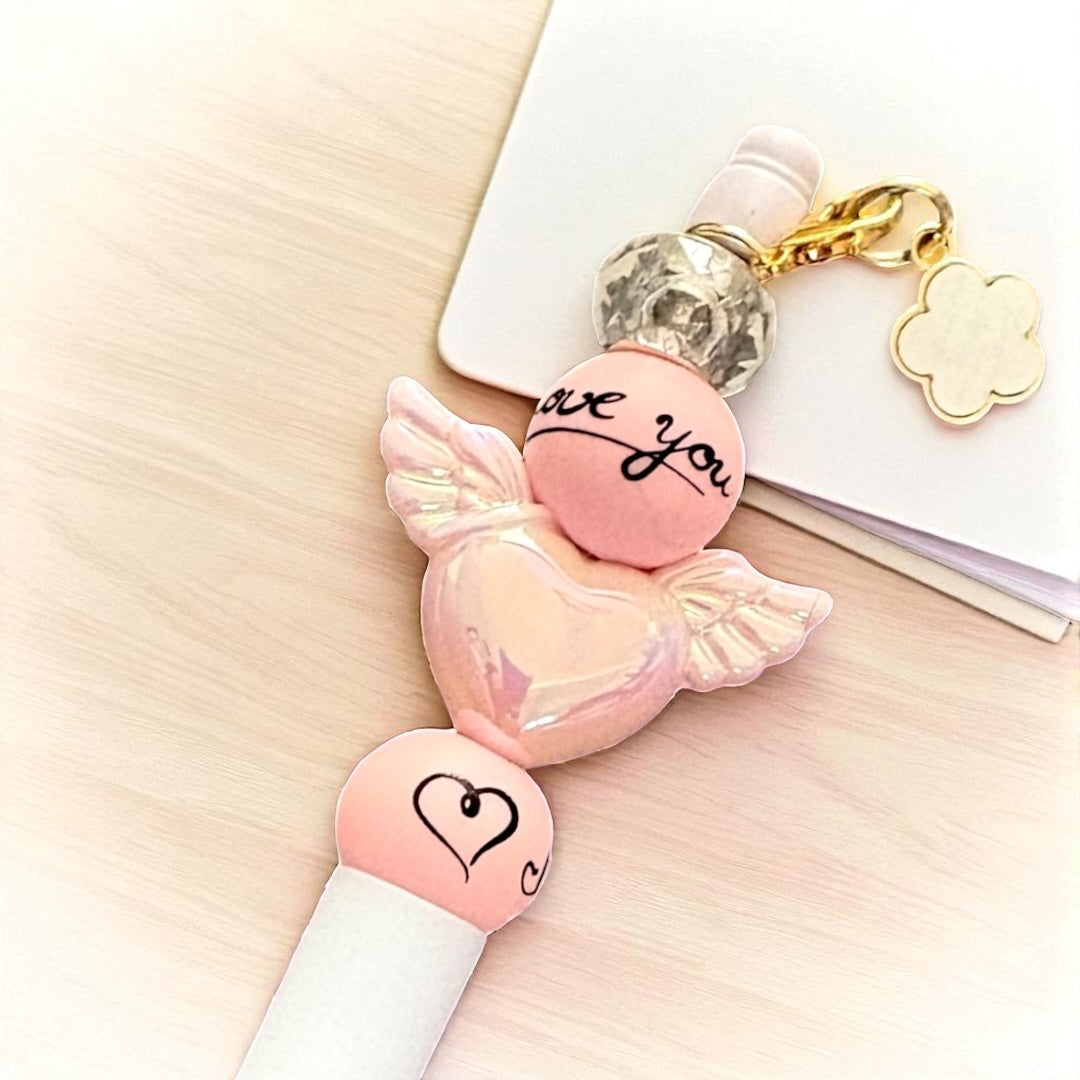 Pink candy-shaped keychain with 'love you' text on a light surface
