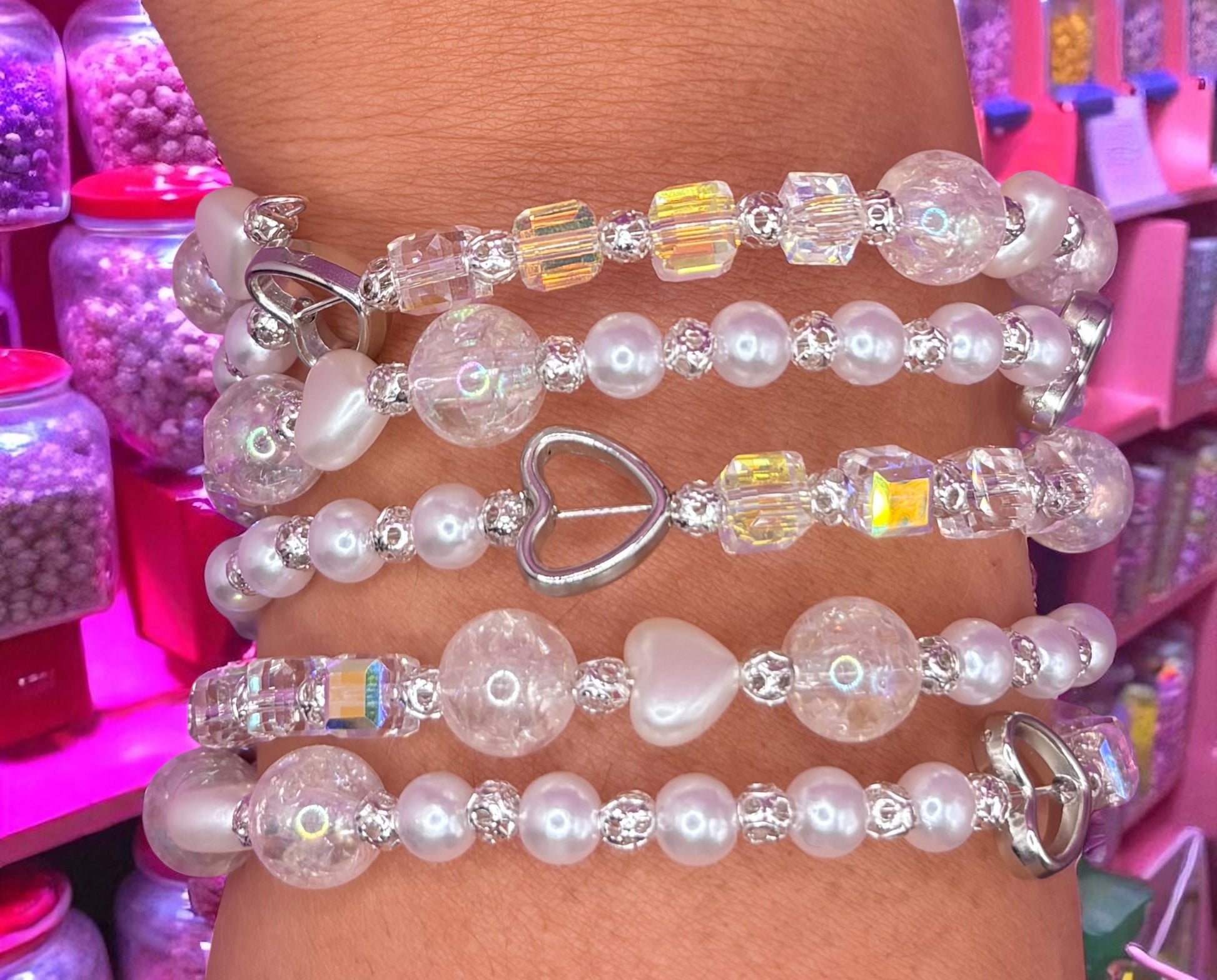 Stack of beaded bracelets on a wrist with a colorful background