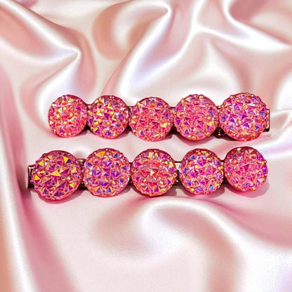Set of pink glittery hair clips on a pink satin background