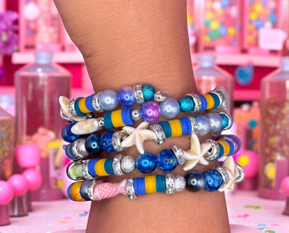 Colorful beaded bracelets on a wrist with a playful background