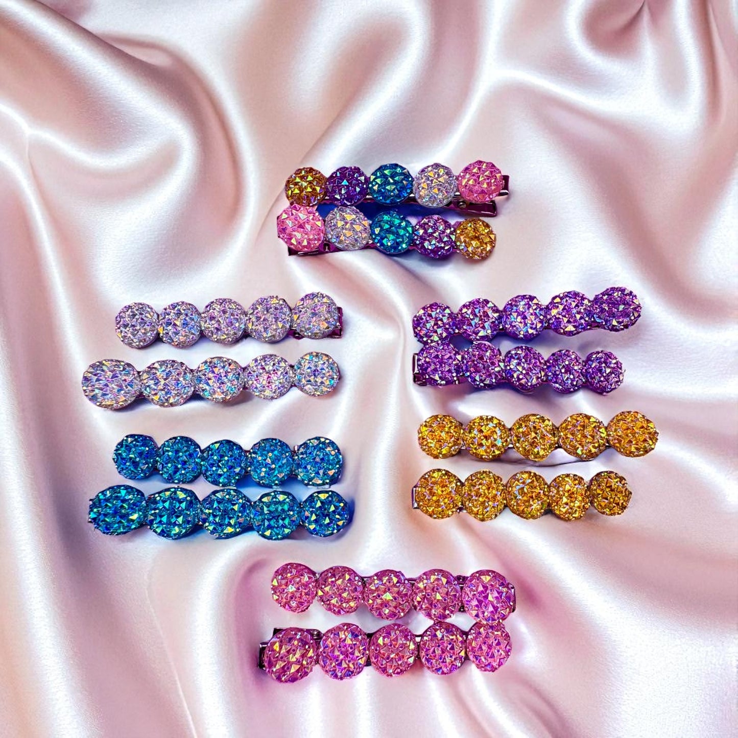 Colorful glittery hair clips on a satin background