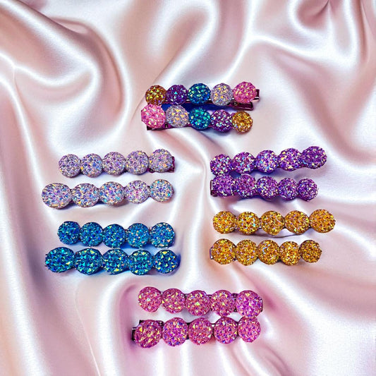 Colorful glittery hair clips on a satin background