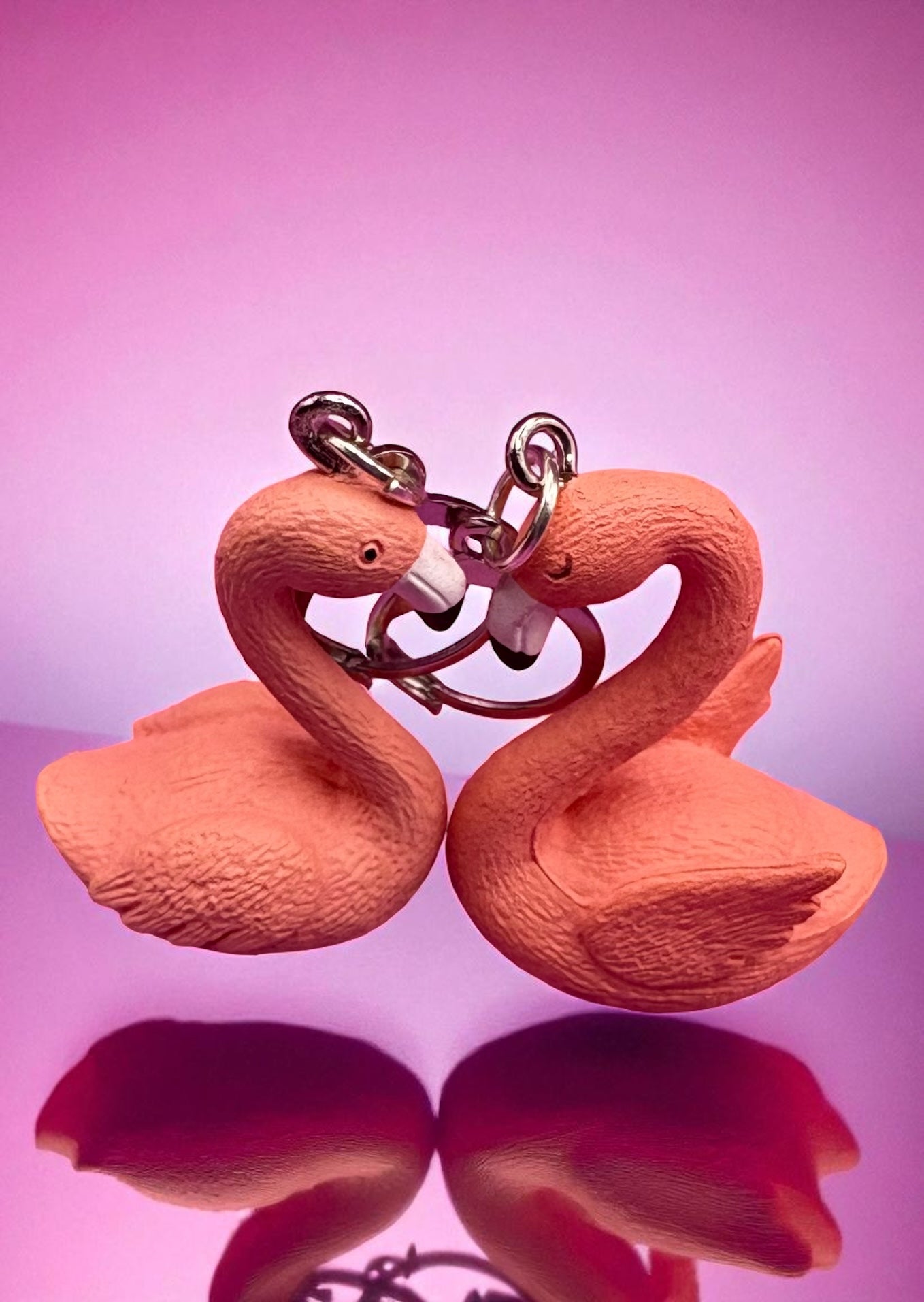 Flamingo-shaped keychain on a pink background