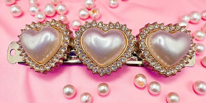 Heart-shaped hair clip with pearls on a pink background