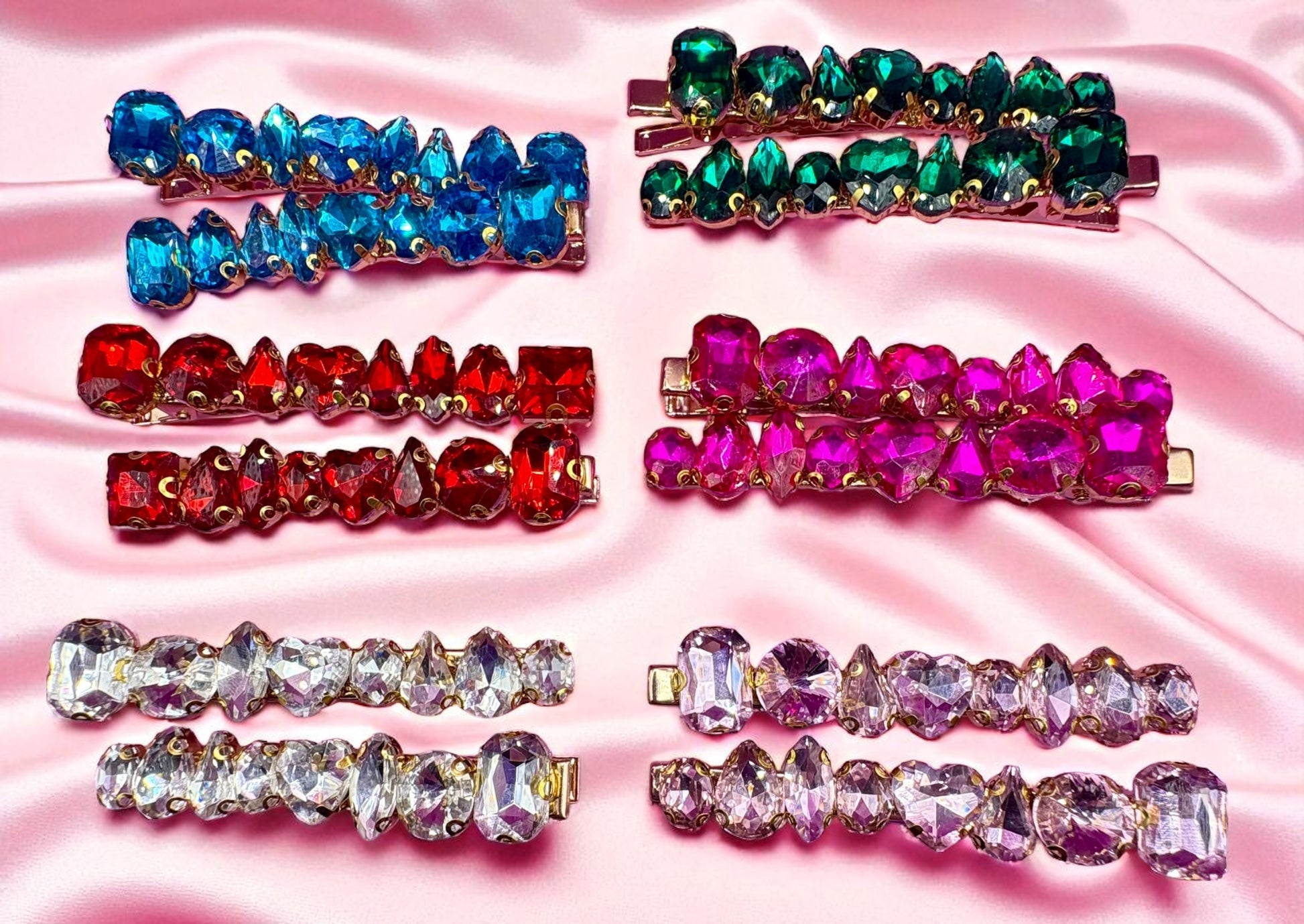 Colorful gemstone hair clips on a pink satin background