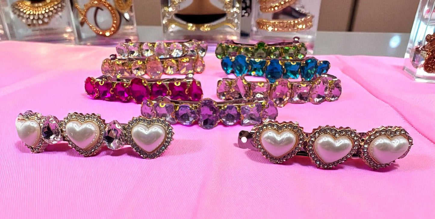 Set of colorful heart-shaped hair clips on a pink surface