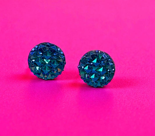 Blue gemstone earrings on a pink background