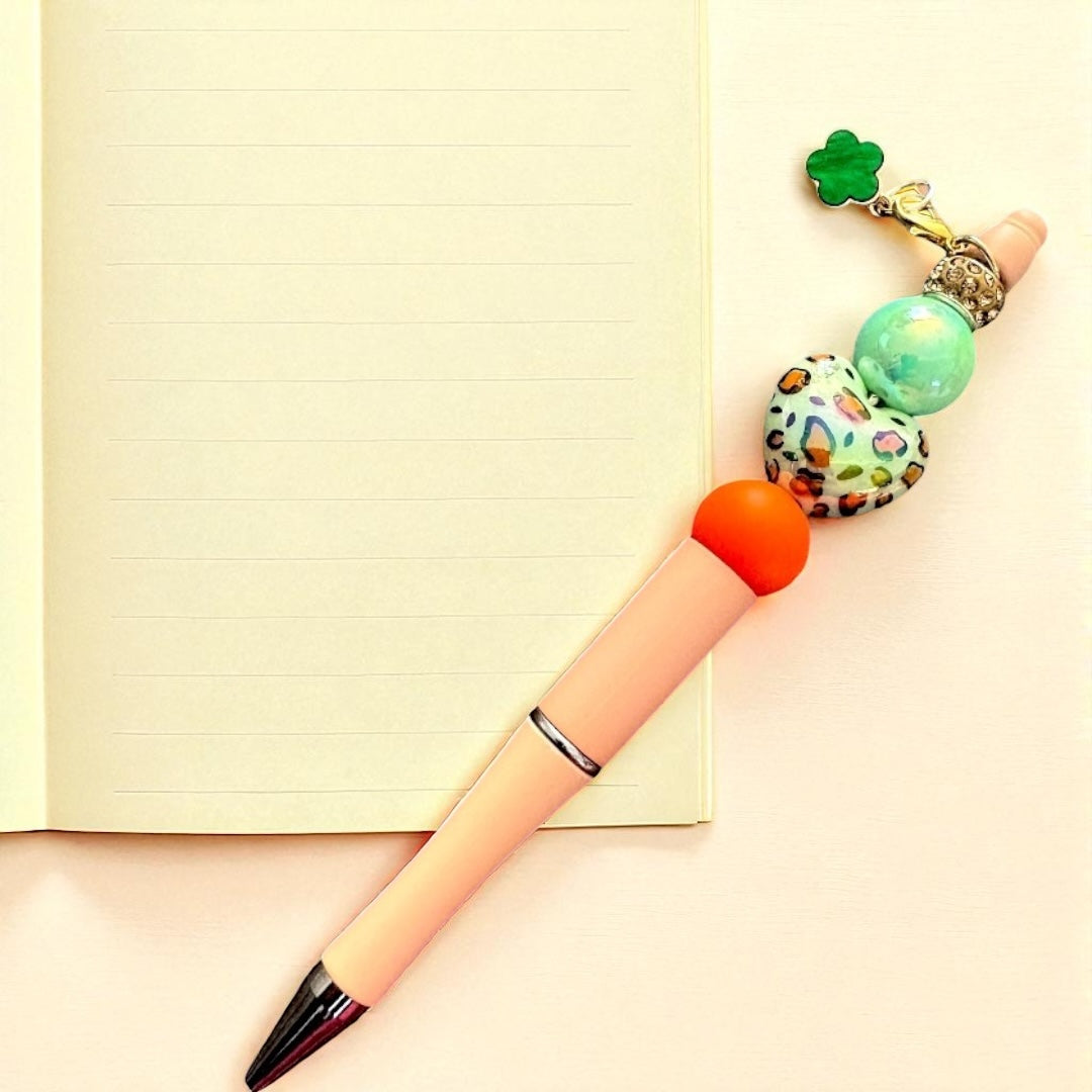 Decorative pen with colorful beads on a light background