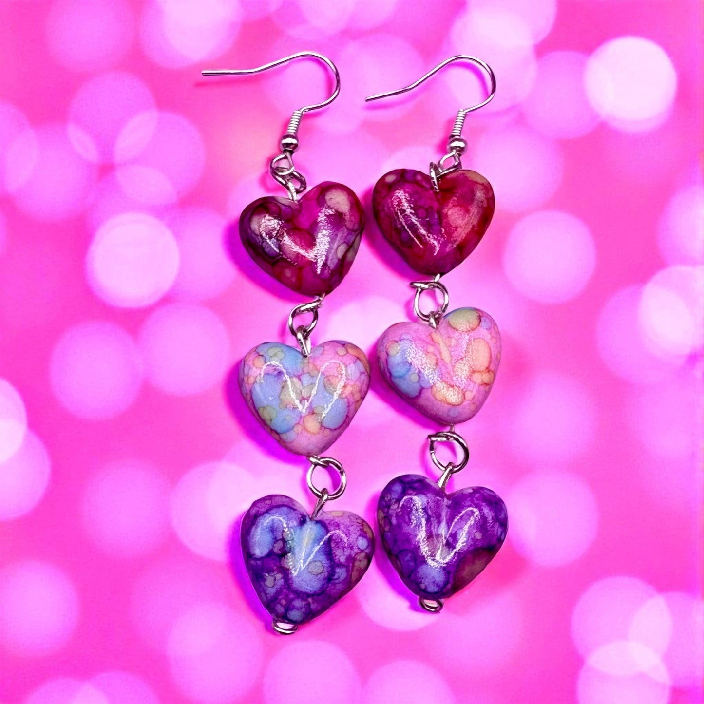 Heart-shaped earrings on a pink background