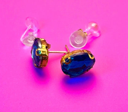 Gold and blue earrings on a pink background