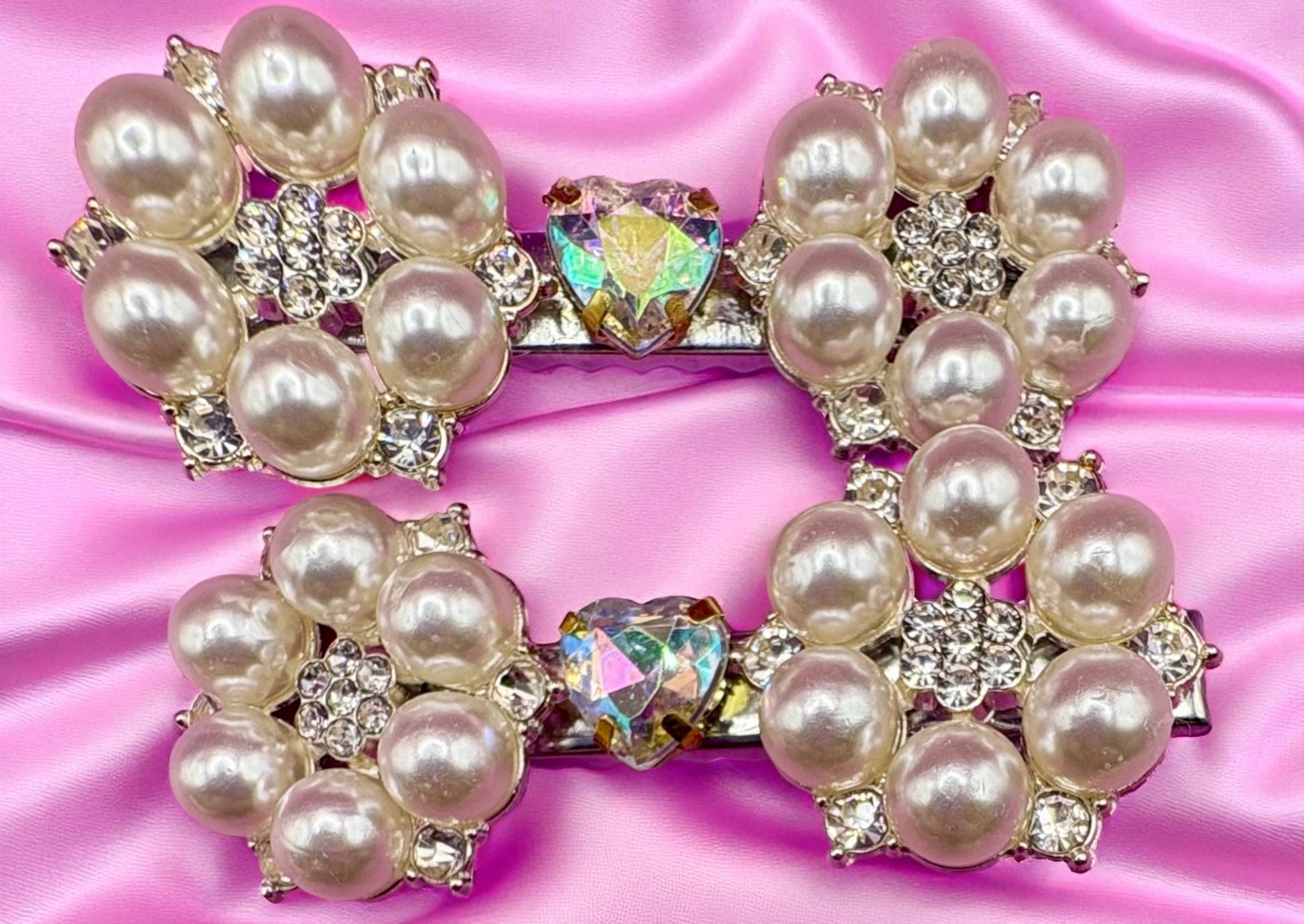 Pearl and crystal hair clips on a pink satin background