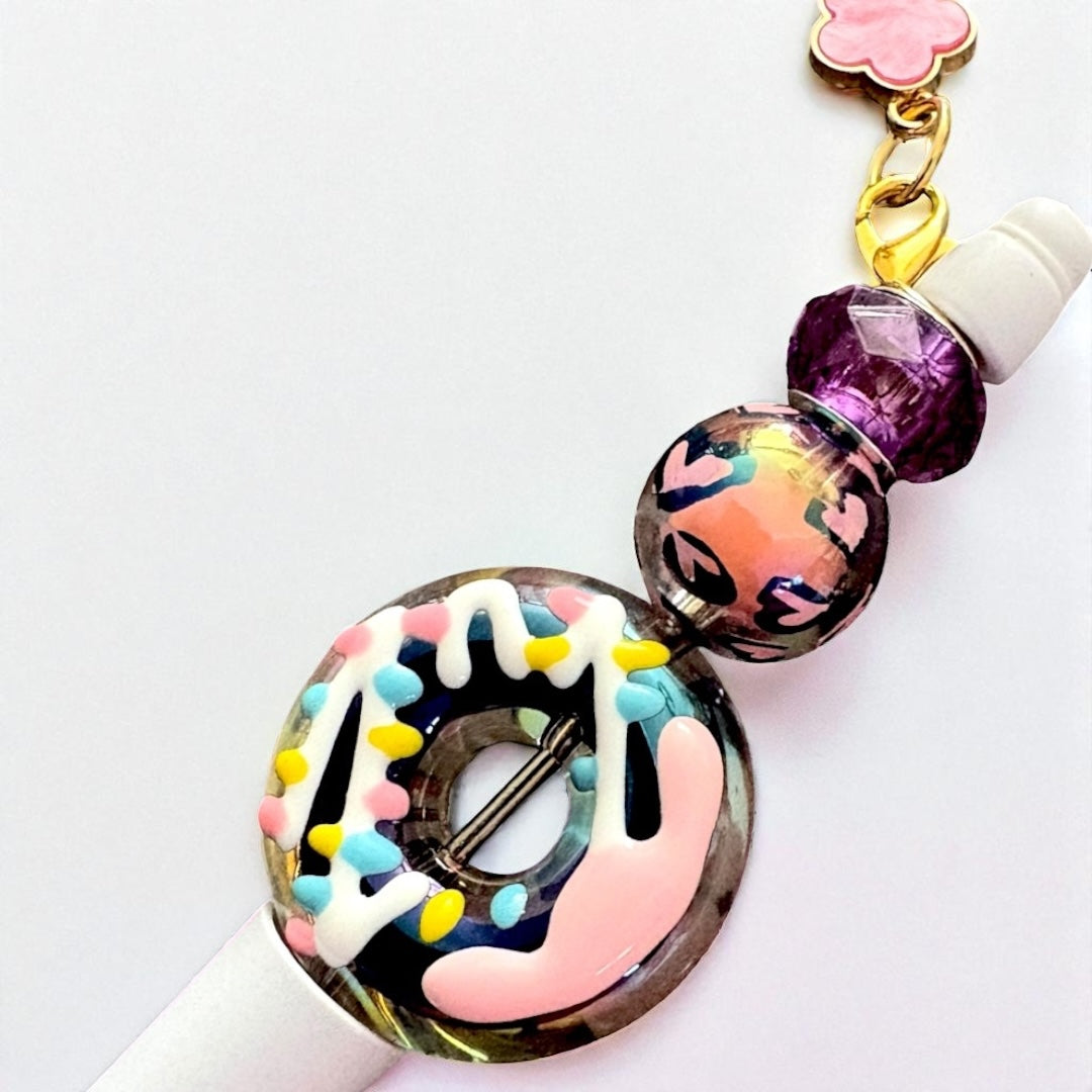 Decorative pen top with colorful donut design on a white background