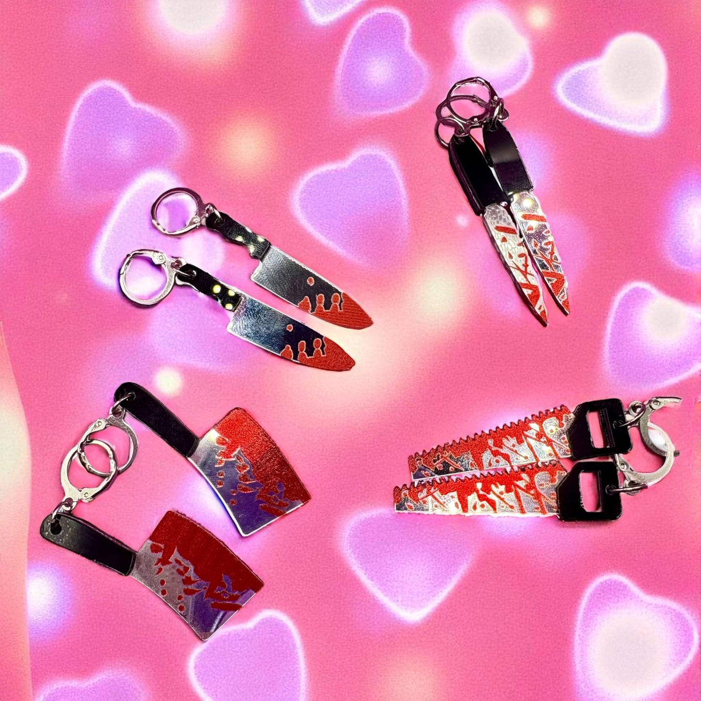 Keychains shaped like knives and a saw on a pink background with heart shapes.