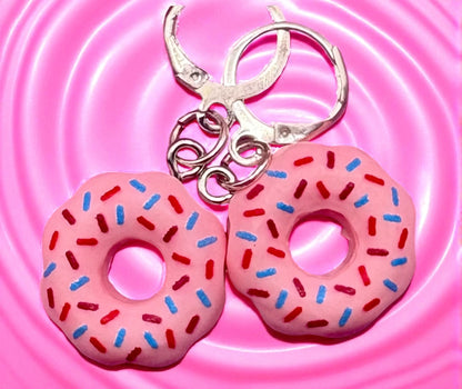 Pink donut  earrings with sprinkles on a pink background