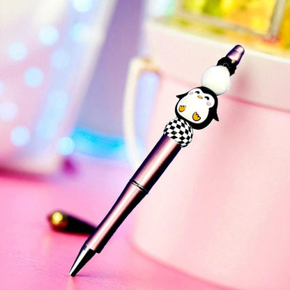 Pen with a penguin-shaped cap on a colorful background