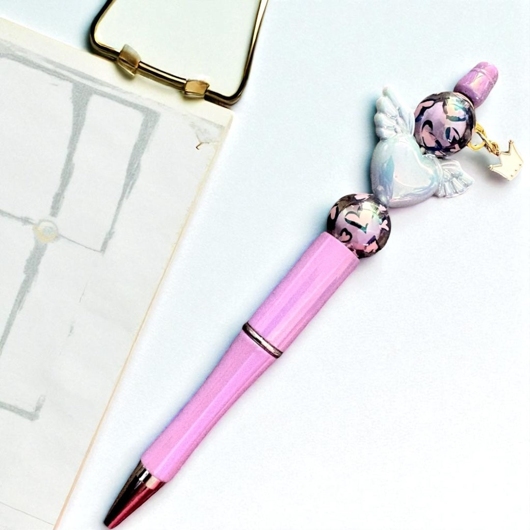 Pink pen with decorative elements on a white surface