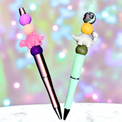 Two colorful pens with decorative tops on a blurred background