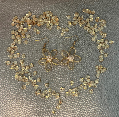 Elegant gold look flower dangly earrings with a pearly center, perfect for adding a touch of sophistication and charm to any outfit.