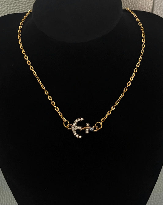 Stylish diamante anchor pendant necklace featuring a protective evil eye charm, perfect for adding a touch of nautical elegance and protection to any outfit.